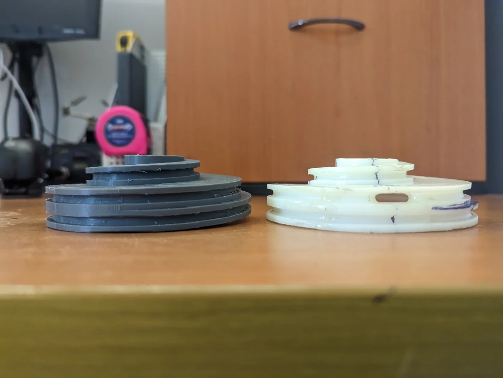 Original and fabricated counterbalance cable pulleys — view 2